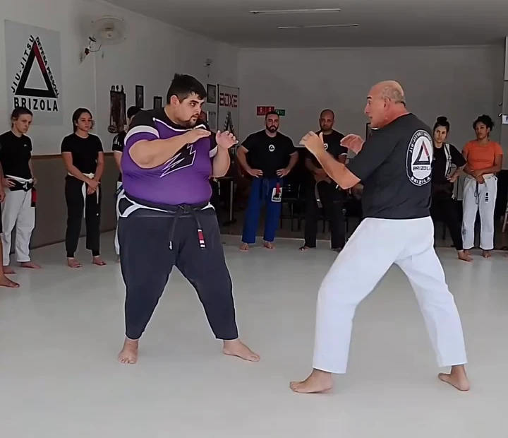 Dois participantes demonstrando uma técnica em pé no seminário de defesa pessoal da Brizola
